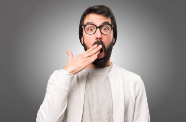 Hipster adam yapma sürpriz jest gri arka plan üzerinde