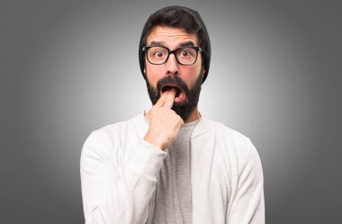 Hipster adam gri arka plan üzerine kusma jest yapma