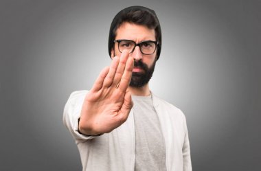 Hipster adam gri arka plan üzerinde kırmızı yapma