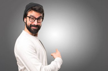 Hipster adam geri gri arka plan üzerine işaret