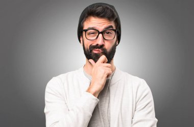 Hipster adam gri arka plan üzerinde düşünme