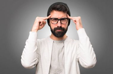 Hipster adam gri arka plan üzerinde düşünme
