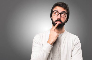 Hipster adam gri arka plan üzerinde düşünme