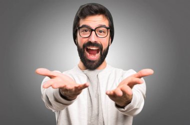 Hipster adam bir şey gri arka plan üzerinde sunulması