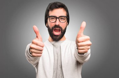 Hipster adam gri arka plan üzerinde başparmak ile