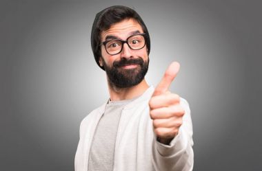 Hipster adam gri arka plan üzerinde başparmak ile