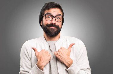 Hipster adam gri arka plan üzerinde başparmak ile