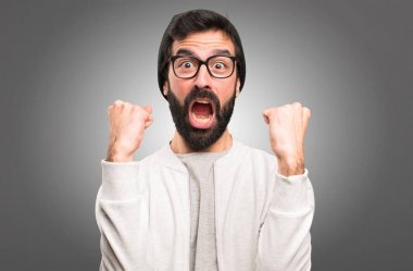 Şanslı hipster adam gri arka plan üzerinde