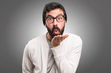 Hipster adam gri arka plan üzerinde bir öpücük gönderme