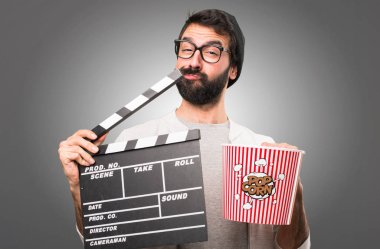 Bir Klaket gri arka plan üzerinde tutarak hipster adam