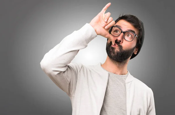 Hipster hombre haciendo gesto borracho sobre fondo gris — Foto de Stock