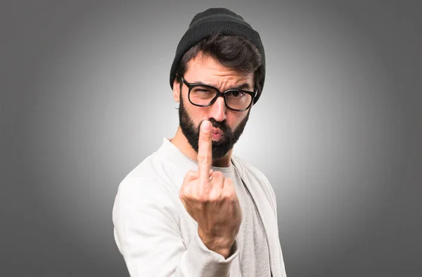 Hipster homem fazendo gesto chifre no fundo cinza — Fotografia de Stock