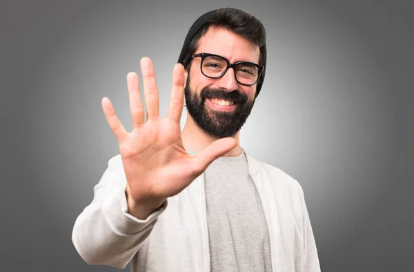 Hipster man räknar fem på grå bakgrund — Stockfoto