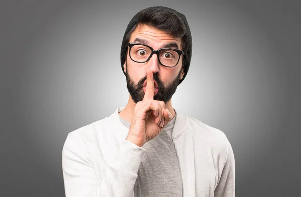 Hipster man making silence gesture on grey background — Stock Photo, Image