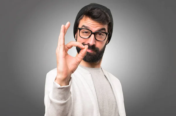 Hipster-Mann macht ok Zeichen auf grauem Hintergrund — Stockfoto