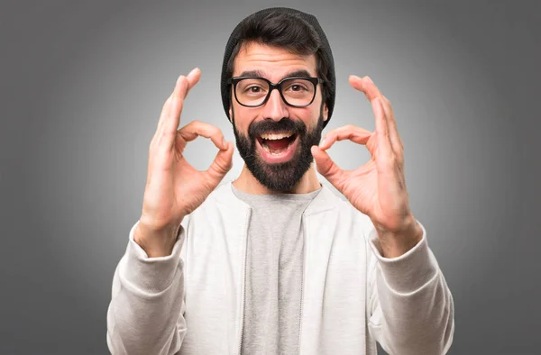 Hipster mannen att göra Ok logga på grå bakgrund — Stockfoto