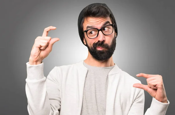 Hipster-Mann macht winziges Schild auf grauem Hintergrund — Stockfoto