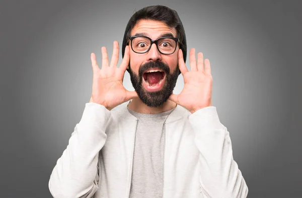 Hipster man making surprise gesture on grey background — Stock Photo, Image