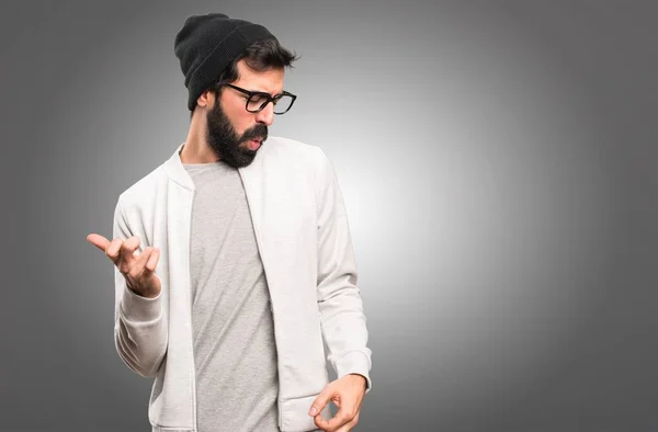 Hipster man making guitar gesture on grey background — Stock Photo, Image
