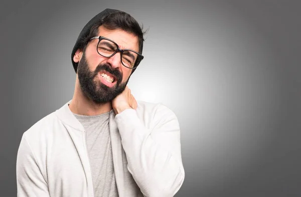 Hipster hombre con dolor de cuello sobre fondo gris — Foto de Stock