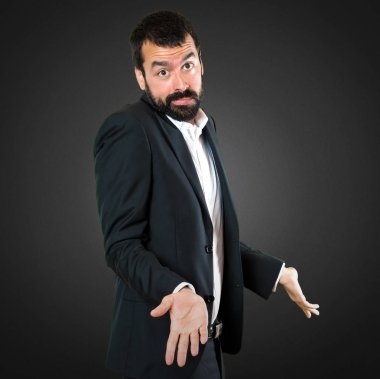 Yakışıklı işadamı üzerinde siyah backgro önemsiz jest yapma