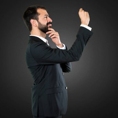 Yakışıklı işadamı küçük işareti siyah arka plan üzerine yapma