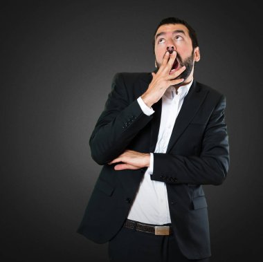 Yakışıklı işadamı yapım sürpriz jest siyah arka plan üzerine