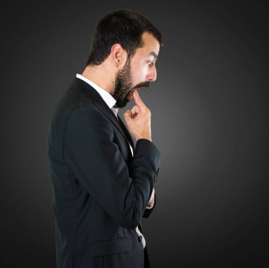 Yakışıklı işadamı siyah arka plan üzerine kusma jest yapma