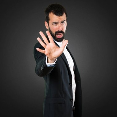 Yakışıklı işadamı siyah arka plan üzerinde kırmızı yapma