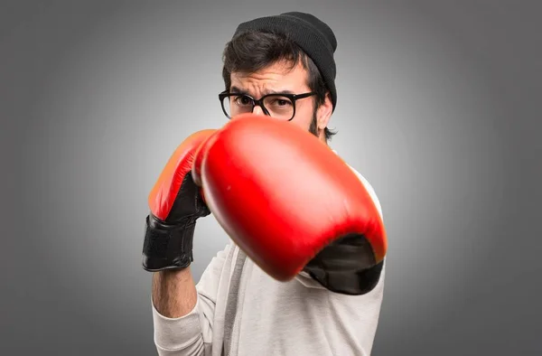 Hipster man with boxing gloves on grey background — Stock Photo, Image