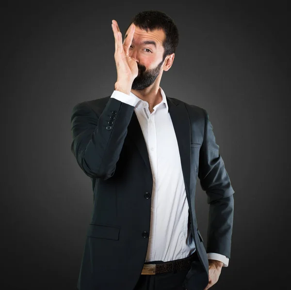 Hombre de negocios guapo haciendo una broma sobre fondo negro — Foto de Stock