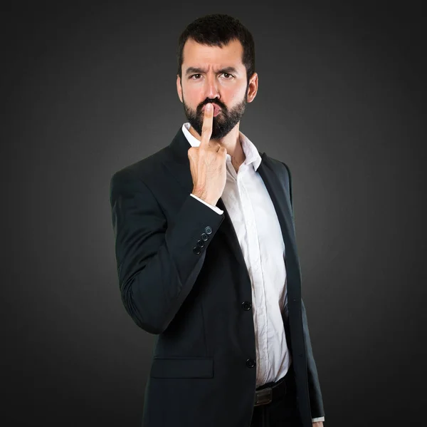 Handsome businessman making horn gesture on black background — Stock Photo, Image