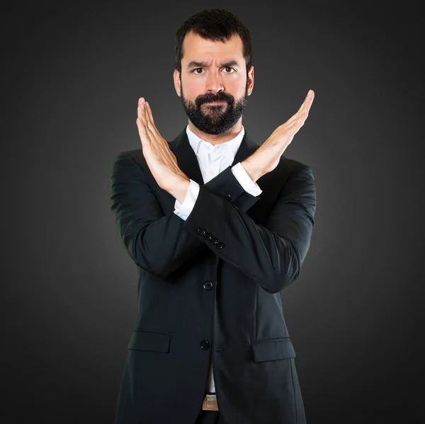 Handsome businessman making NO gesture on black background — Stock Photo, Image