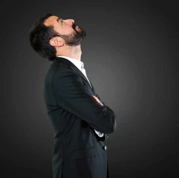 Hombre de negocios guapo mirando hacia arriba en el fondo negro — Foto de Stock