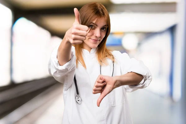 Giovane donna medico facendo segno buono-cattivo in ospedale — Foto Stock