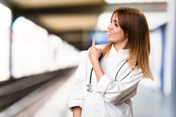 Junge Ärztin zeigt zurück ins Krankenhaus — Stockfoto