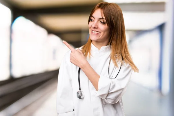 Junge Ärztin zeigt auf die Seite im Krankenhaus — Stockfoto