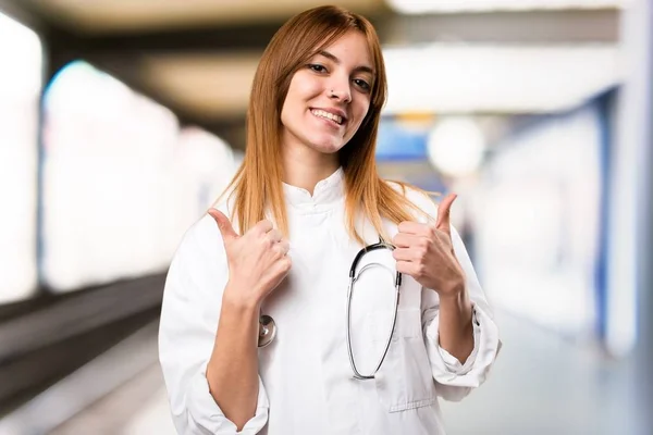 Fiatal orvos nő hüvelykujjával a kórházban — Stock Fotó