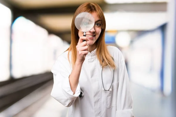 Jonge dokter vrouw met vergrootglas in het ziekenhuis — Stockfoto