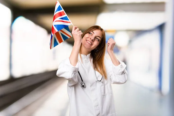 若い医者病院でイギリスの旗を保持している女性 — ストック写真