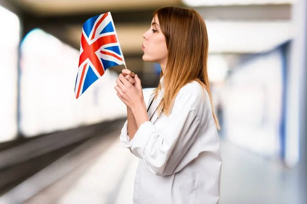 若い医者病院でイギリスの旗を保持している女性 — ストック写真