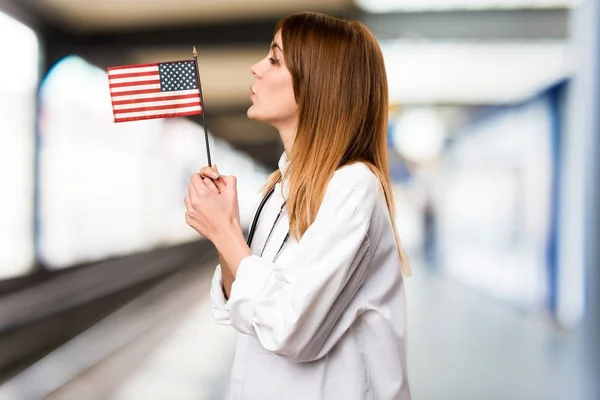 若い医者病院でアメリカの国旗を保持している女性 — ストック写真