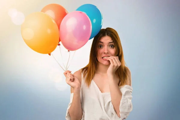 Verängstigte schöne junge Mädchen hält einen Luftballon auf unkonzentrierten b — Stockfoto