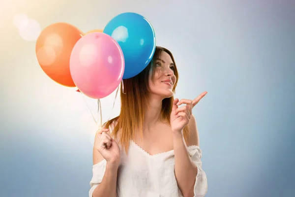 Beautiful young girl holding a balloon and thinking on unfocused