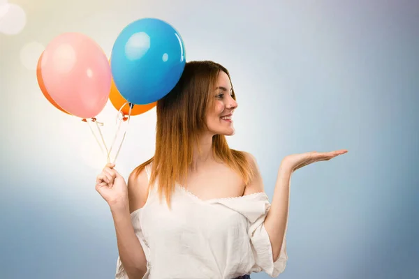 Schöne junge Mädchen hält einen Luftballon und hält etwas auf — Stockfoto