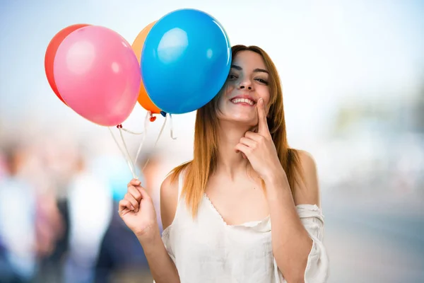 Feliz bela menina segurando um balão no backgr desfocado — Fotografia de Stock