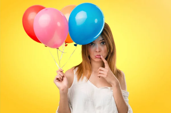 Sad beautiful young girl holding a balloon on unfocused backgrou — Stock Photo, Image