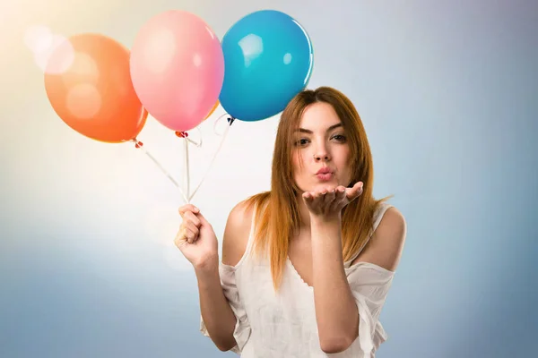 Hermosa joven sosteniendo un globo y enviando un beso en unf —  Fotos de Stock
