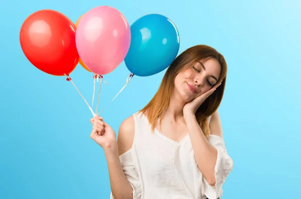 Menina bonita segurando um balão e fazendo gesto de sono — Fotografia de Stock