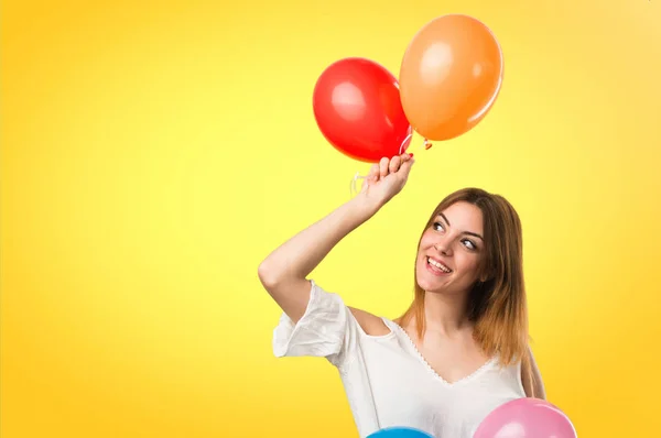 Feliz hermosa joven sosteniendo un globo en backgr desenfocado — Foto de Stock